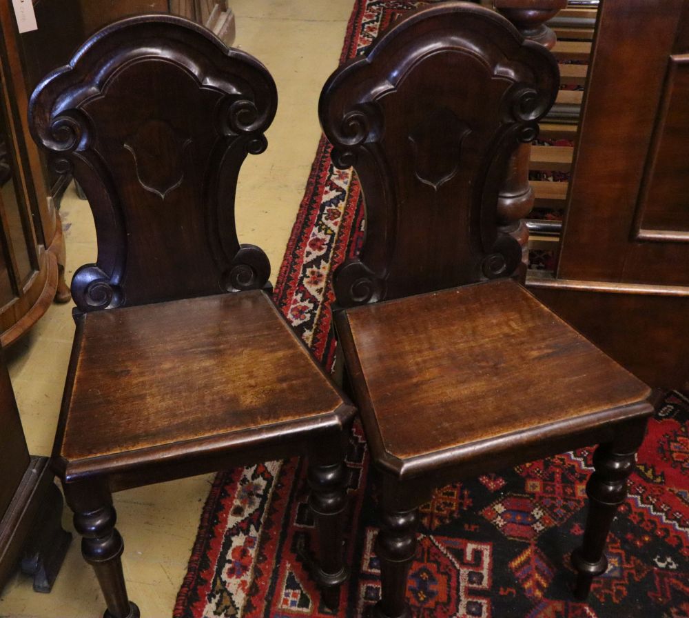 A Regency mahogany correction chair, a George III mahogany hall chair and two Victorian hall chairs